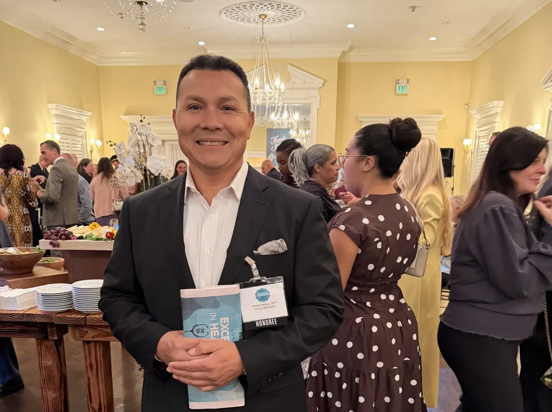 Hector Melgar, DPT, de Clínica Bienestar con su credencial de HONOREE en los HERALD Long Island Excellence in Healthcare Awards 2026
